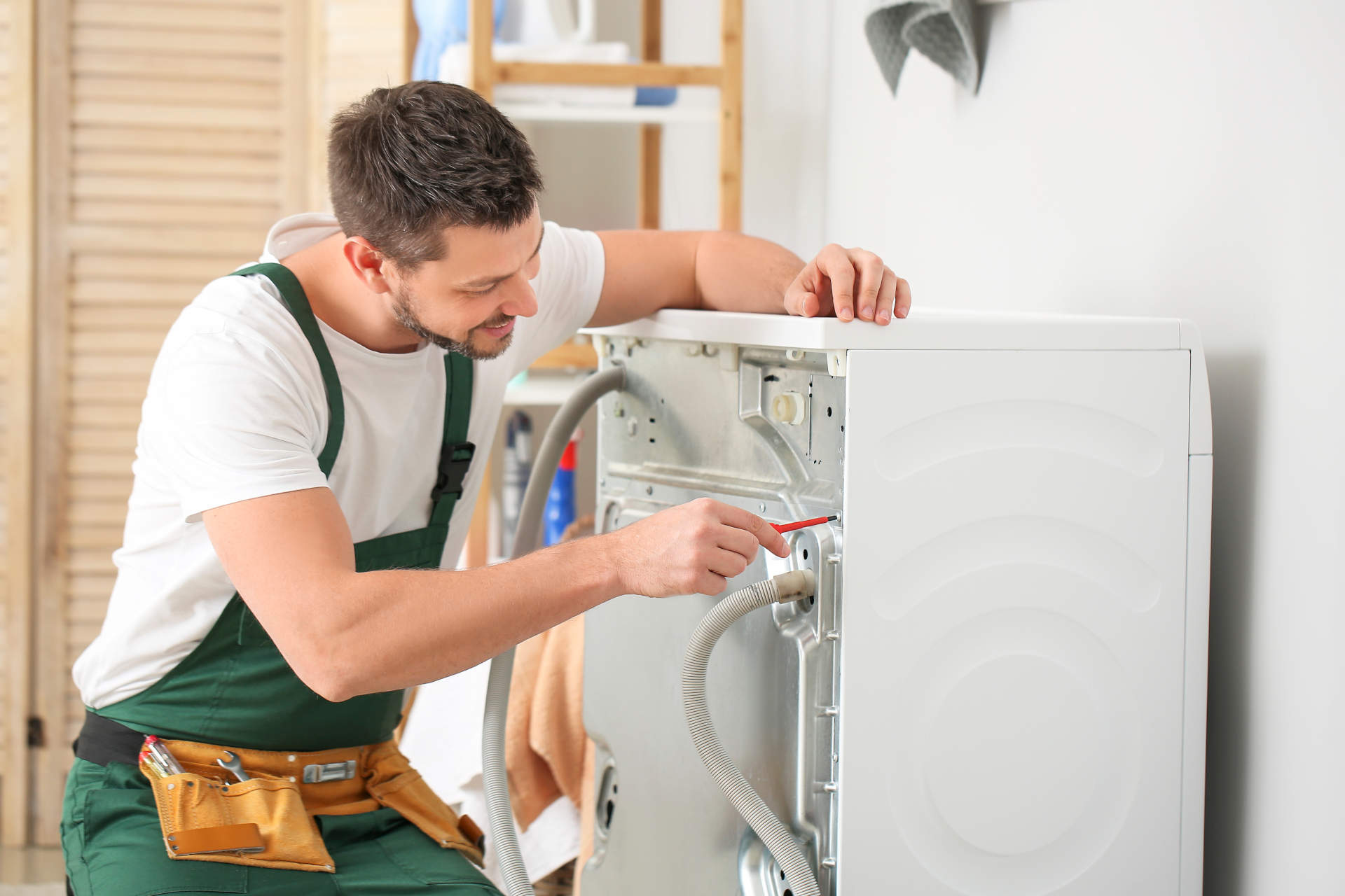 Ein Mann repariert eine Waschmaschine