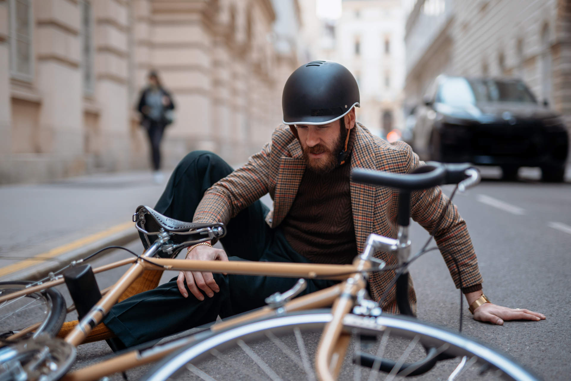 Ein Mann ist vom Fahrrad gefallen und sitzt auf der Straße